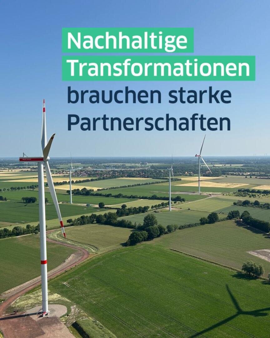 A landscape with several wind turbines in green fields under a blue sky. The overlaid text in German reads: Sustainable transformations need strong partnerships.