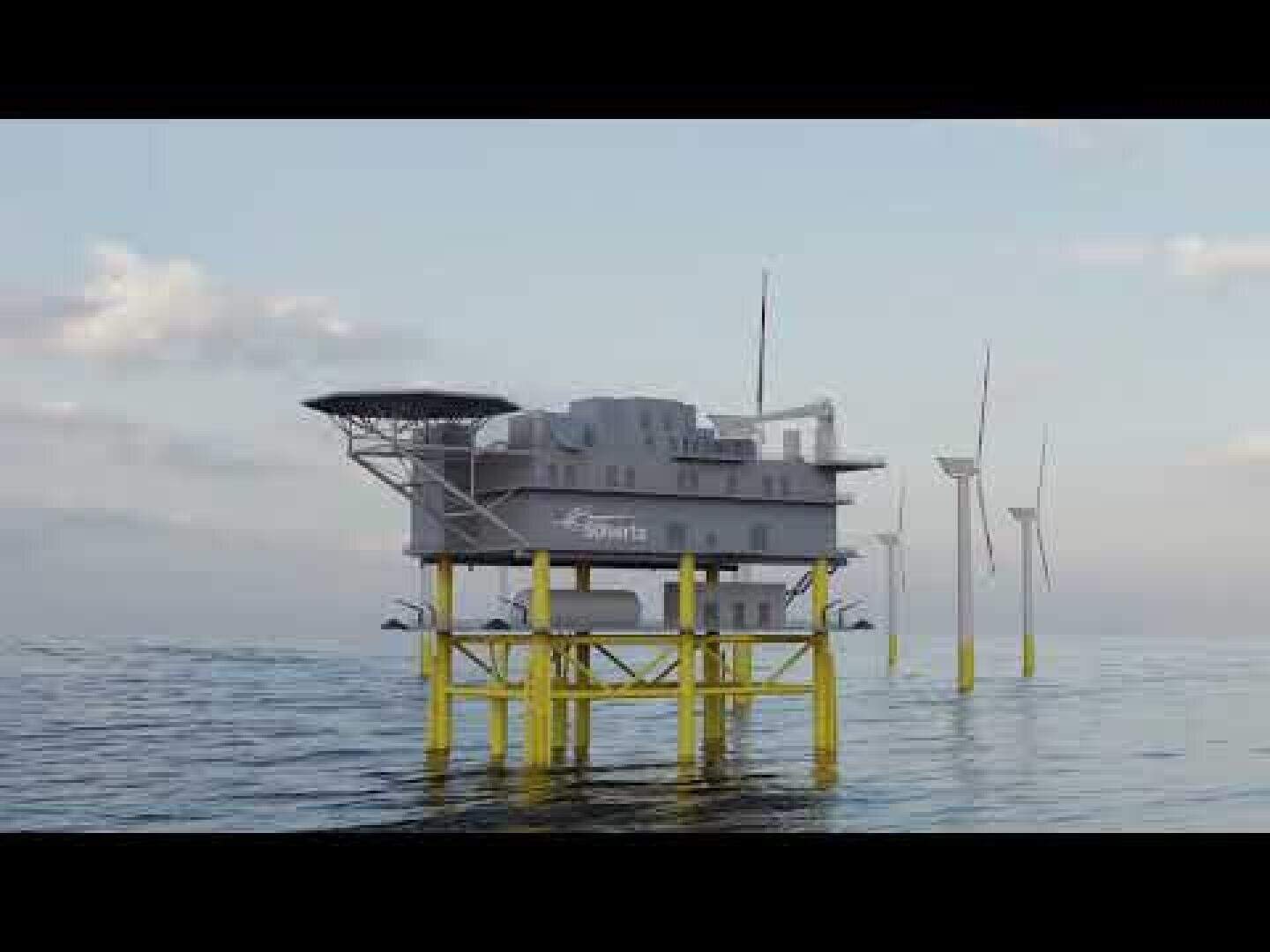 An offshore platform with yellow supports stands in the sea, featuring a gray building labeled Siemens. Wind turbines are visible in the background under a partly cloudy sky.