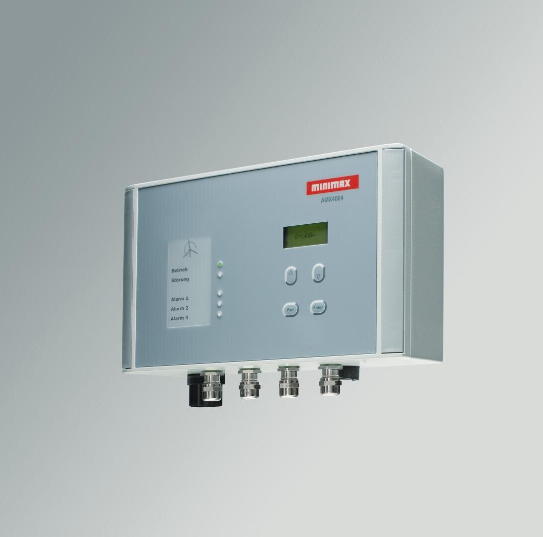 A rectangular electronic control panel labeled minimax AMI2000 with a small screen, several buttons, indicator lights and four cable connections on the underside, mounted on a light grey wall.