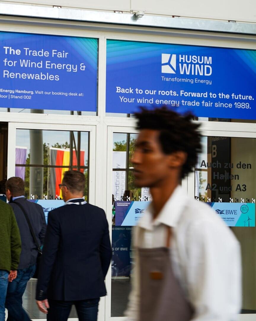 Menschen, die durch die gläsernen Eingangstüren der Messe Husum Wind gehen.