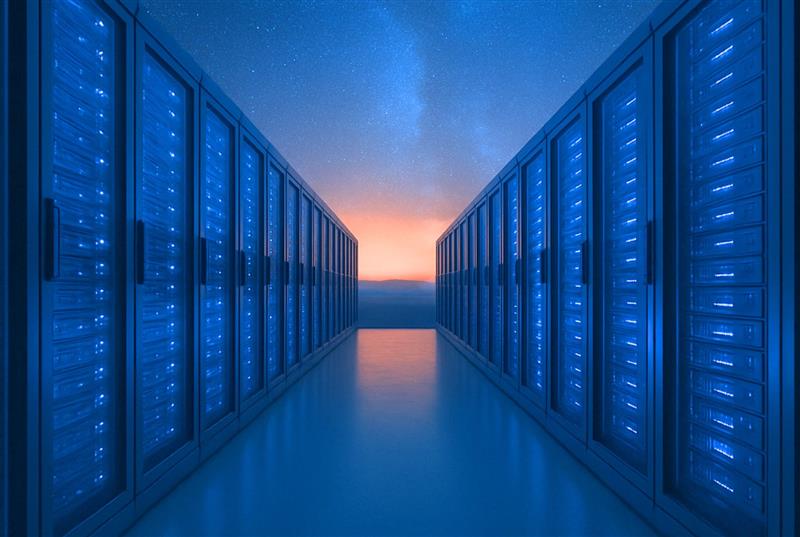 Ein Korridor zwischen zwei Reihen von blau beleuchteten Server-Racks in einem Rechenzentrum, mit einem glühenden Horizont und einem Sternenhimmel im Hintergrund.