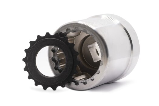 A close-up of a shiny mechanical metal part with a black gear wheel at its opening, isolated on a white background.